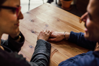 Couple sitting on table and holding hands