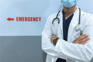 Free Healthcare worker in emergency room with stethoscope and facemask, cross-armed posture