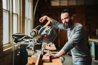 Man posing with table saw.